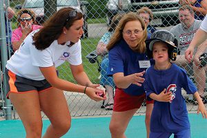 Volunteers encourage a Miracle League hitter