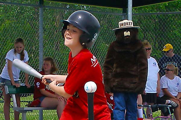 Batter swings at the ball on a tee